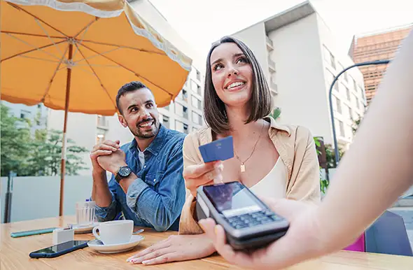 A couple at a restaurant paying with a debit card - payment processing